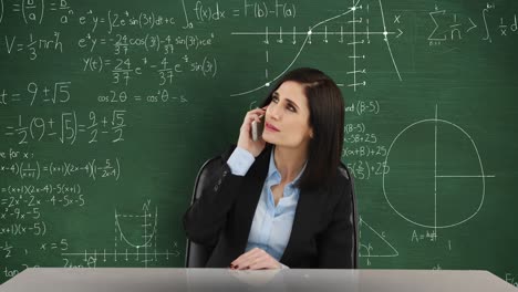 Mujer-Hablando-Por-Teléfono-Frente-A-Una-Pizarra-Con-Cálculos-Matemáticos-En-Movimiento-4k