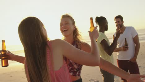 Young-adult-friends-drinking-on-a-beach-at-sunset-4k