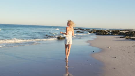 Young-woman-having-fun-running-on-beach-4k