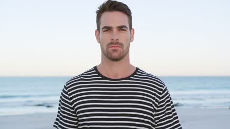 Portrait-of-a-young-man-standing-on-a-beach-4k