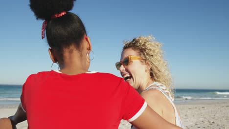 Two-young-adult-female-friends-having-fun-at-the-beach-4k