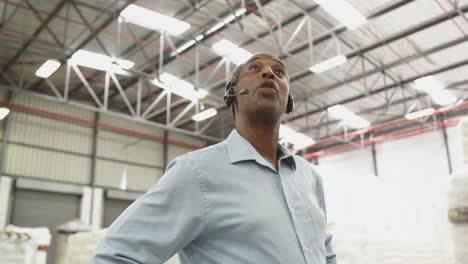 Close-up-of-a-male-warehouse-worker-using-headset-in-a-storeroom-4k