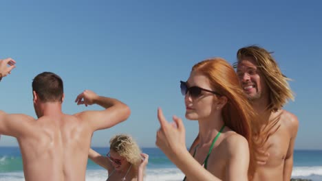 Young-adult-friends-dancing-at-the-beach-4k