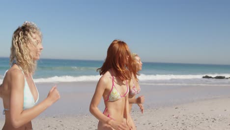Young-adult-female-friends-running-at-the-beach-4k