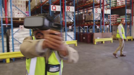 Male-warehouse-worker-using-VR-headset-and-controller-in-loading-bay-4k