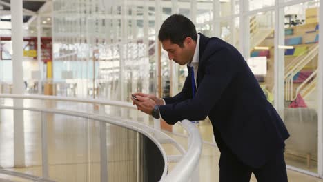 Businessman-using-a-smartphone-in-a-conference-foyer