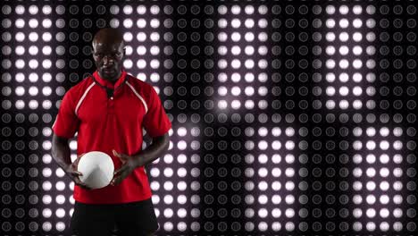 Professional-rugby-player-holding-a-ball-in-front-of-digital-display