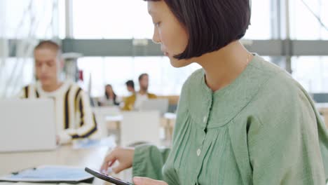 Woman-using-smartphone-working-in-a-modern-office
