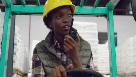 Female-worker-driving-forklift-in-a-warehouse