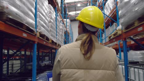 Young-female-worker-walking-in-a-warehouse