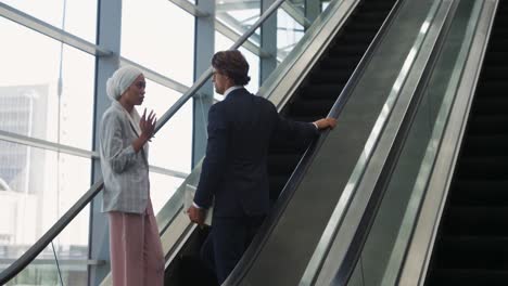 Young-business-people-on-an-escalator-in-a-modern-building