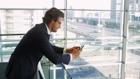 Hombre-De-Negocios-Usando-Un-Teléfono-Inteligente-En-Un-Moderno-Edificio-De-Oficinas