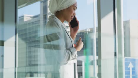 Businesswoman-using-smartphone-in-modern-office-building