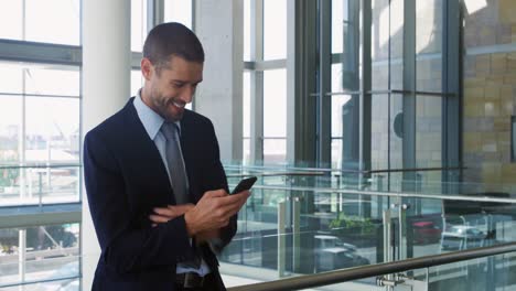 Businessman-using-smartphone-in-modern-office-building
