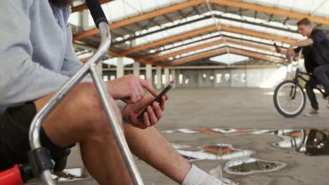 BMX-riders-using-smartphones-in-an-empty-warehouse