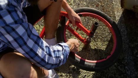 BMX-rider-repairing-wheel