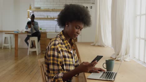 Woman-using-smartphone-and-laptop-at-home
