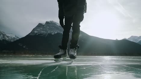 Low-section-of-man-skating-on-a-frozen-lake
