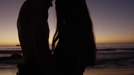 Junges-Erwachsenes-Paar-Entspannt-Am-Strand-Bei-Sonnenuntergang