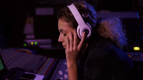 Female-sound-engineer-working-at-a-mixing-desk