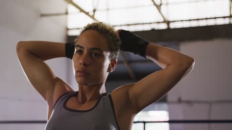 Mixed-race-woman-stretching-in-boxing-ring