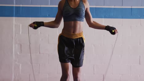 Mixed-race-woman-working-out-in-boxing-gym