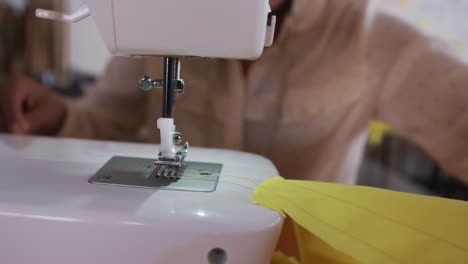 Mixed-race-woman-sewing-in-fashion-office