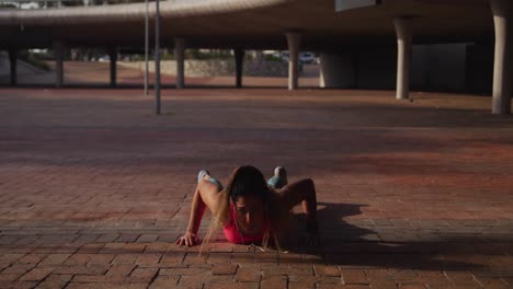 Caucasian-woman-doing-push-ups-under-a-bridge