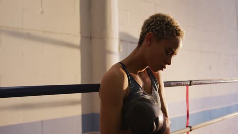 Mixed-race-woman-adjusting-boxing-gloves