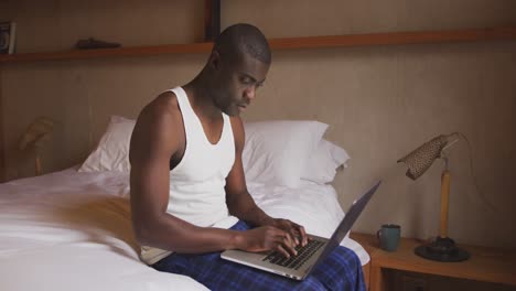 Afroamericano-Usando-Computadora-En-El-Dormitorio