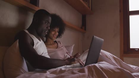 Couple-using-computer-in-bedroom-at-home