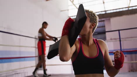 Mixed-race-woman-happy-to-win-in-boxing-gym
