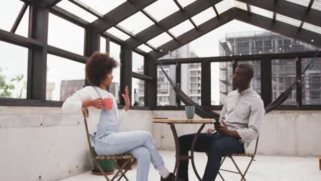 African-man-and-mixed-race-woman-discussing-on-rooftop