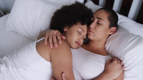 Lesbian-couple-sleeping-on-bed-in-bedroom