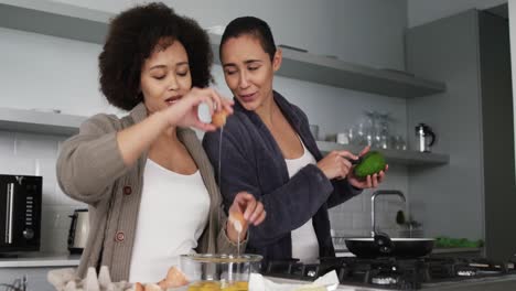 Lesbian-couple-preparing-breakfast-in-kitchen