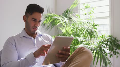 Mixed-race-man-using-digital-tablet-in-creative-office