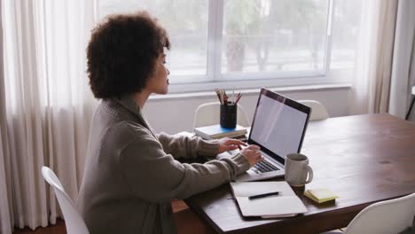 Woman-working-on-laptop-while-sitting-at-table
