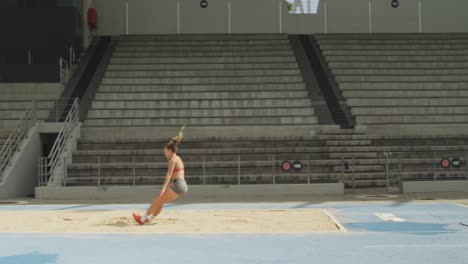 Side-view-of-caucasian-athlete-doing-long-jump