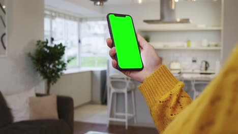 Woman-using-smartphone-in-kitchen