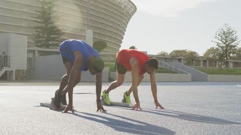 Two-athletes-preparing-for-race-in-stadium