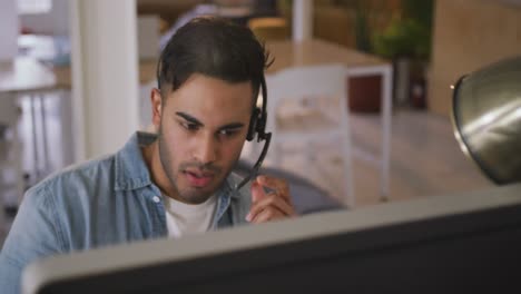 Mixed-race-man-phoning-in-creative-office