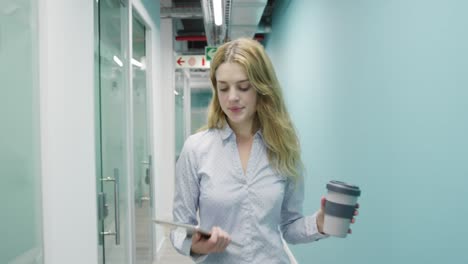 Woman-walking-with-phone-and-coffee-on-her-hands