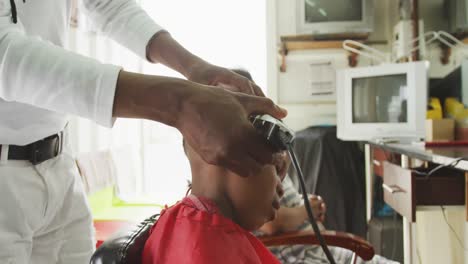 African-man-cutting-African-boy-hair-