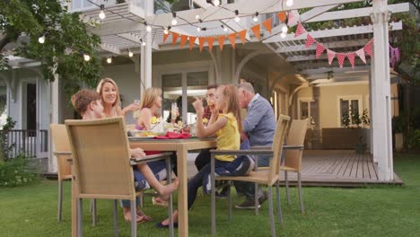 Three-generation-family-enjoying-lunch-outdoors