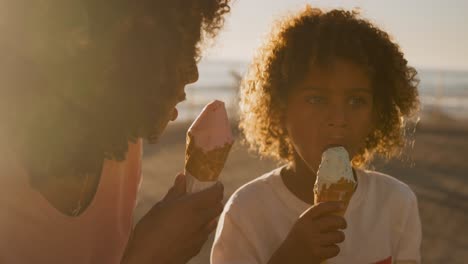 Mother-and-son-eating-ice-cream-with-sea-in-background-