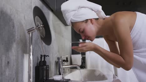 Caucasian-woman-washing-face-in-hotel