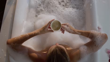 Caucasian-woman-drinking-coffee-while-taking-bath-in-hotel