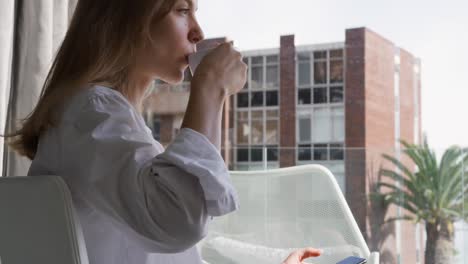 Side-view-of-caucasian-woman-drinking-coffee-in-hotel