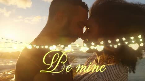 Couple-in-love-on-the-beach-with-Be-Mine-written-in-golden-letters-
