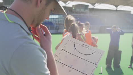 Hockey-coach-making-game-plan-with-female-players-